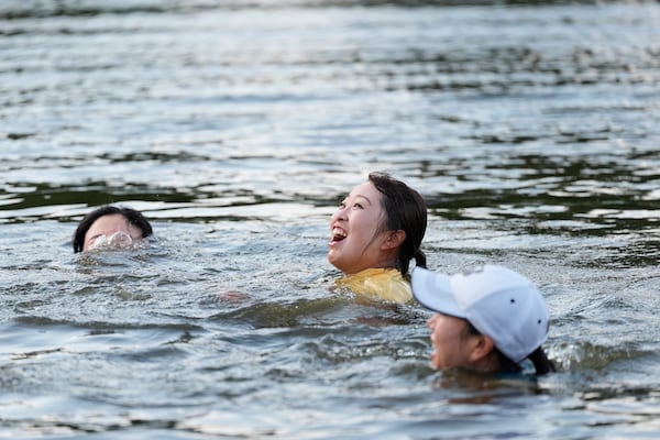 Mao Saigo, of Japan, in yellow, swims in the water after winning the Chevron Championship LPGA golf tournament Sunday, April 27, 2025, in The Woodlands, Texas. (AP Photo/Ashley Landis)