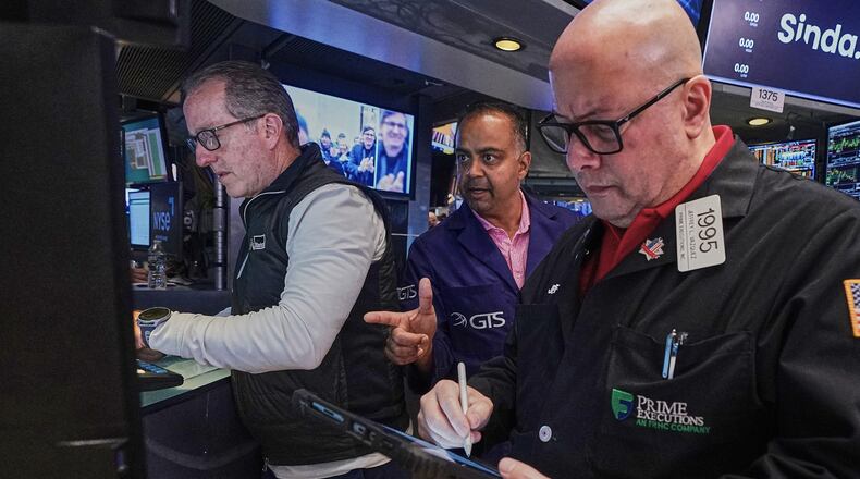 Specialist Glenn Carell, left, and Dilip Patel, center, work with trader Jeffrey Vazquez on the floor of the New York Stock Exchange, Friday, June 26, 2026. (AP Photo/Richard Drew)