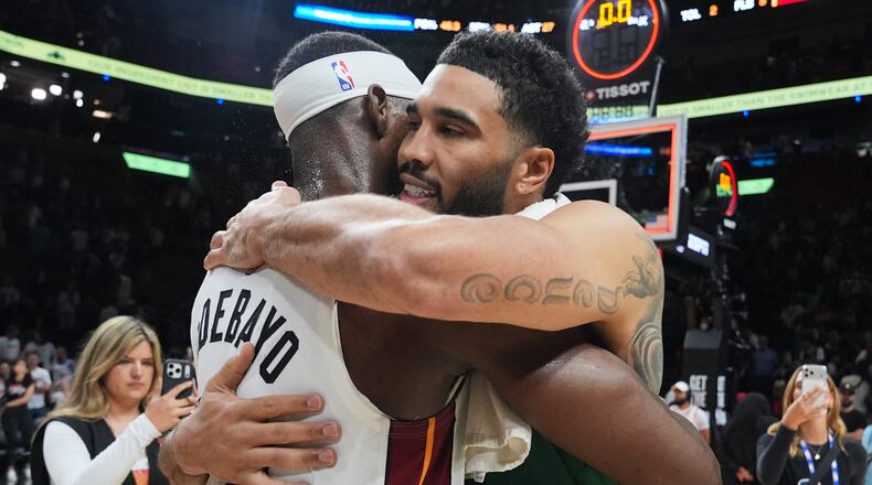 Miami Heat center Bam Adebayo (13) and Boston Celtics forward Jayson Tatum, right, embrace after an NBA basketball game, Wednesday, April 1, 2026, in Miami. (AP Photo/Lynne Sladky)