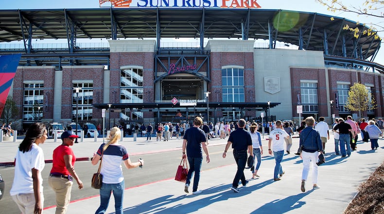 FILE - In this March 31, 2017, file photo, fans head to SunTrust Park before the Atlanta Braves open their new ballpark for an exhibition spring training baseball game against the New York Yankees, in Atlanta. After a short 20-year stay at Turner Field, the Braves begin their SunTrust Park era on Friday night, April 14 in their home opener against the San Diego Padres. (AP Photo/David Goldman, File)