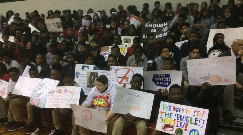 Students at Mundy’s Mill Middle School in Clayton County, some with anti-gun posters, gathered in the gym for a ceremony honoring slain Florida students and demanding action.