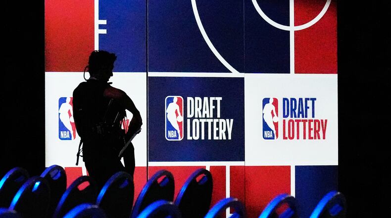 A person walks by a sign in the NBA basketball draft lottery in Chicago, Sunday, May 10, 2026. (AP Photo/Nam Y. Huh)