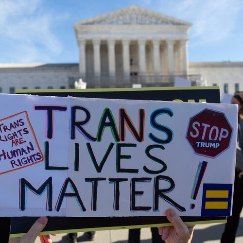 Protesters gather outside the Supreme Court as it hears arguments over state laws barring transgender girls and women from playing on school athletic teams, Tuesday, Jan. 13, 2026, in Washington. (AP Photo/Jose Luis Magana)
