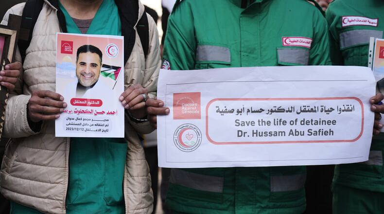 Medical staff take part in a protest organized by the Palestinian Prisoners Committee calling for the release of prisoners held in Israeli prisons outside the Red Cross headquarters in Gaza City Monday, Jan. 12, 2026. (AP Photo/Jehad Alshrafi)