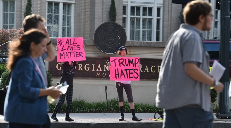 June 15, 2016: Donald Trump supporters wait in line as protestors hold signs across the street from the historical Fox Theatre. The Presumptive Republican presidential nominee,Donald Trump, is holding a rally at the theater Wednesday at noon. BRANT SANDERLIN/BSANDERLIN@AJC.COM