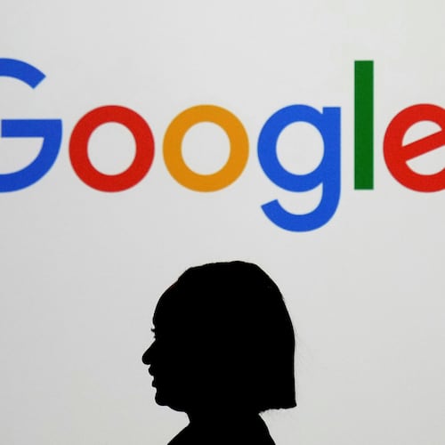 FILE - A woman walks by a giant screen displaying the Google logo at an event at the Paris Google Lab on the sidelines of the AI Action Summit in Paris, Feb. 9, 2025. (AP Photo/Thibault Camus, File)