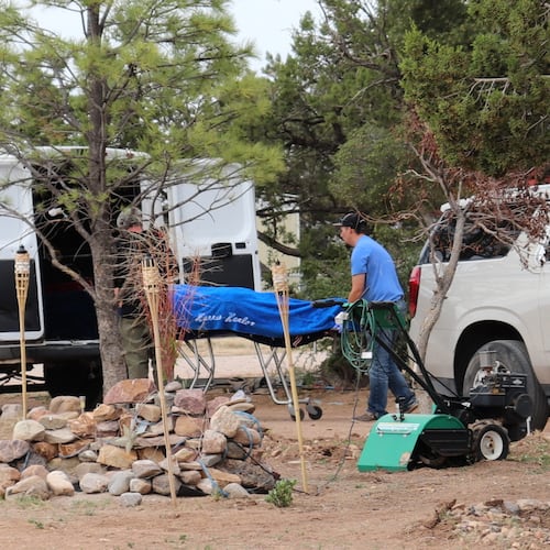 Workers remove a body in Mountainair, N.M., Wednesday, May 20, 2026, after several people died and more than a dozen first responders were exposed to an unknown substance. (AP Photo/Savannah Peters)