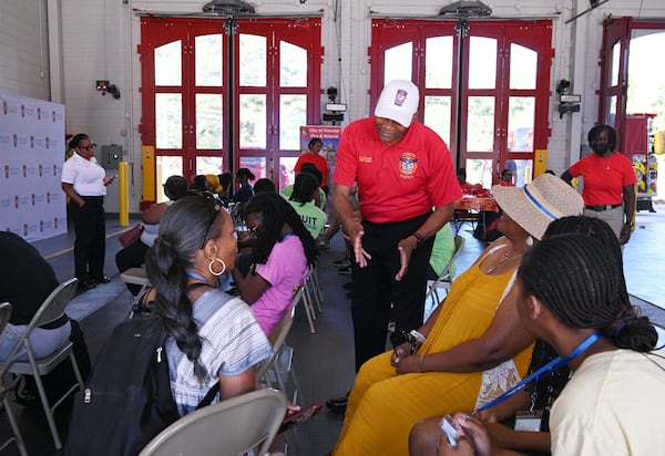 Former DeKalb County fire Chief Darnell Fullum (standing) greets participants before the start of Females in the Fire. Fullum is now director of public safety. (Hyosub Shin/AJC)