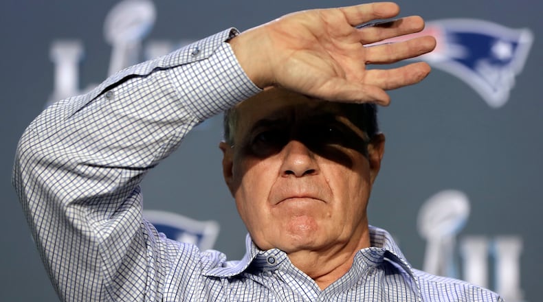 New England Patriots head coach Bill Belichick shields his eyes from the lights as he listens to a question during a news conference Tuesday, Jan. 30, 2018, in Minneapolis.