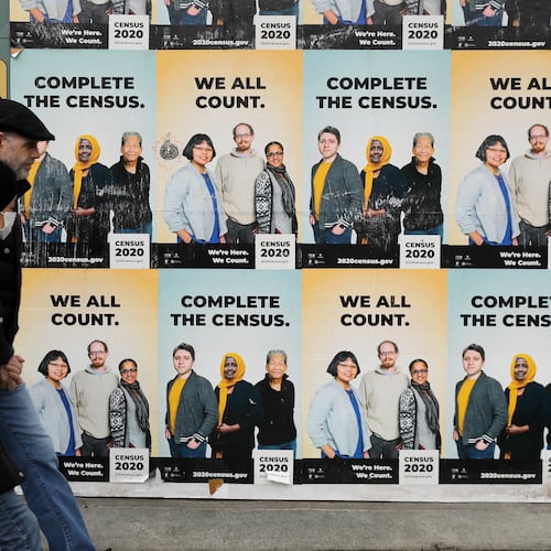 FILE - In this Wednesday, April 1, 2020 file photo,People walk past posters encouraging participation in the 2020 Census in Seattle's Capitol Hill neighborhood. (AP Photo/Ted S. Warren, File)