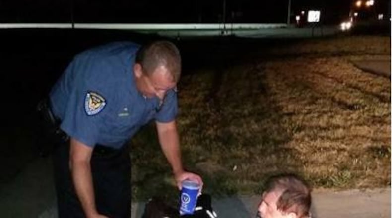 A photo posted to Middletown Division of Police Facebook page showed an officer giving a homeless man a pizza and drink. PHOTO CREDIT: Facebook