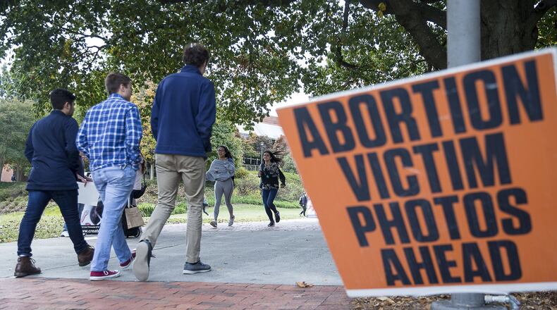 Students walk past graphic abortion photographs during a Cerated Equal organizational event at Georgia Tech’s campus in Atlanta on Monday. The Created Equal organization visited the campus with large photographs and video of aborted fetuses.