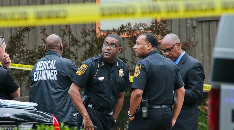 n this file photo, DeKalb County police officials confer at the scene where two women were found shot dead on May 19, 2014.