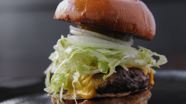 The Hank, served at Illegal Food, is a house-ground burger served with American cheese, shredded iceberg, sweet Vidalia onion, house-made dill pickle and special sauce. (Becky Stein / beckysteinphotography.com)