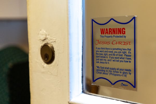 Some scripture is attached to the door leading into First Liberty Building & Loan's office in Newnan. On its website, First Liberty said it would “honor God in everything we do.” (Arvin Temkar/AJC)