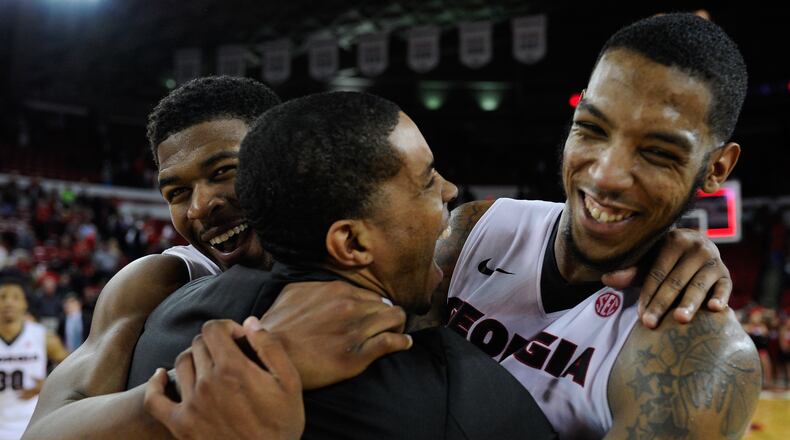 Georgia guards Kenny Gaines, left, and guard Charles Mann, right, hug assistant coach Yasir Rosemond after their 70-63 win over Alabama in an NCAA college basketball game, Saturday, March 5, 2016, in Athens, Ga. (AJ Reynolds/Athens Banner-Herald via AP) MAGS OUT; MANDATORY CREDIT