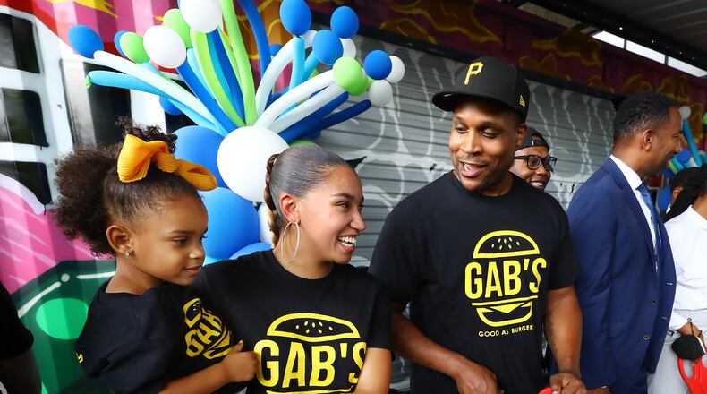 071322 Atlanta: Good As Burgers owners Talia Jones, her daughter Bella Skyy, 3, and her fiancee Corney Watking participate in a ribbon cutting ceremony for the inaugural BeltLine MarketPlace collaboration under the Freedom Parkway Bridge, on Wednesday, July 13, 2022, in Atlanta. The new pilot program offers pop-up storefront space for local, Black-owned businesses including Good As Burgers in refurbished shipping containers along the Atlanta BeltLine in two different areas.  “Curtis Compton / Curtis Compton@ajc.com”