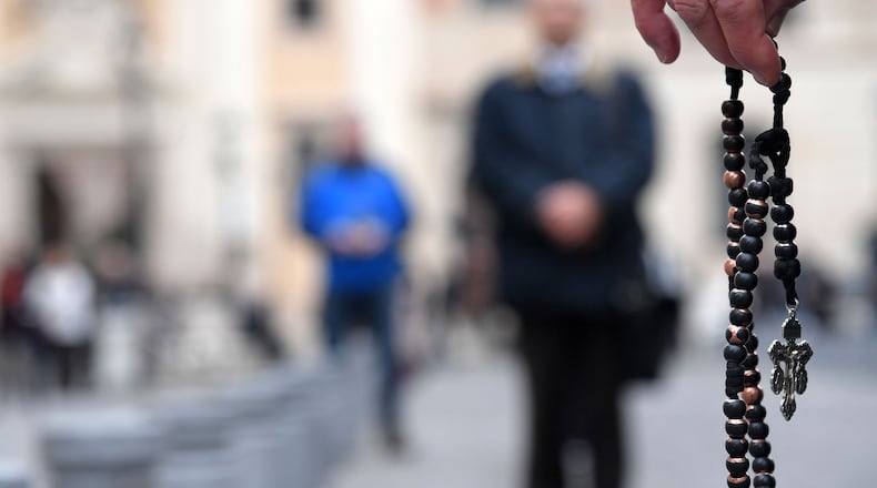 Members of an international coalition of lay people known as "Acies Ordinata", one holding a rosary during a demonstration in Piazza San Silvestro in downtown Rome on February 19, 2019, to denounce what they call a "Wall of Silence" regarding child sexual abuse within the Catholic Church worldwide. (Tiziana Fabi/AFP/Getty Images/TNS)