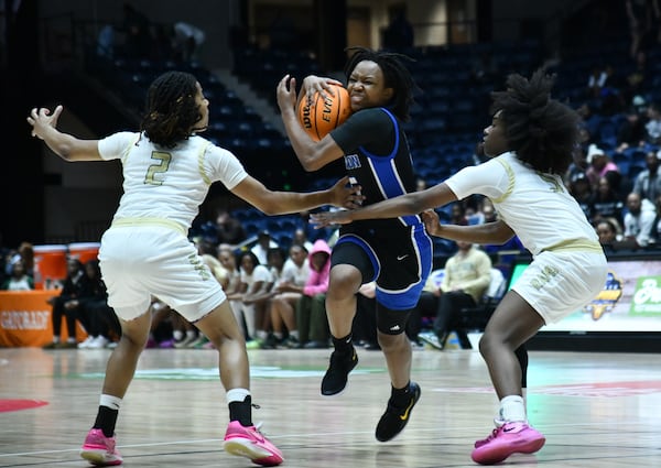 Newton's London Smith (center) drives against Grayson's Tatum Brown (2) and Grayson's Zoie Lofton (right) during the second half of the GHSA Girls 6A State Championship at the Macon Centreplex, Saturday, March 8, 2025, in Macon. Newton won 59-56 over Grayson. (Hyosub Shin / AJC)