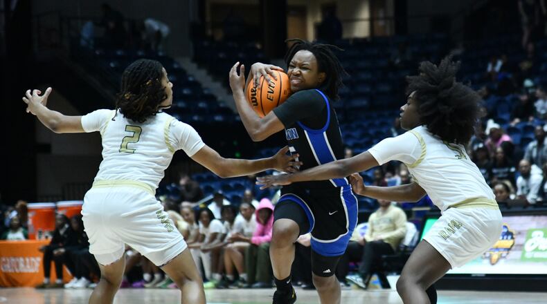 Newton's London Smith (center) drives against Grayson's Tatum Brown (2) and Grayson's Zoie Lofton (right) during the second half of the GHSA Girls 6A State Championship at the Macon Centreplex, Saturday, March 8, 2025, in Macon. Newton won 59-56 over Grayson. (Hyosub Shin / AJC)