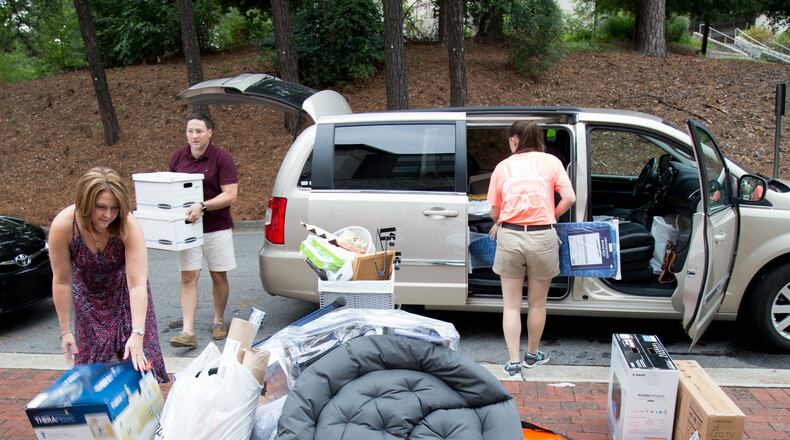 Jeff Ribel (L) and Shannon Ribel (R) off load dorm room supplies for their freshmen son Matt during Emory’s move-in day in 2015. STEVE SCHAEFER / SPECIAL TO THE AJC