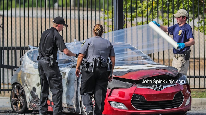 Authorities wrap up a burned car for transport to the GBI. The body of 55-year-old Vincent Marsh was found inside the car on July 18, 2019.