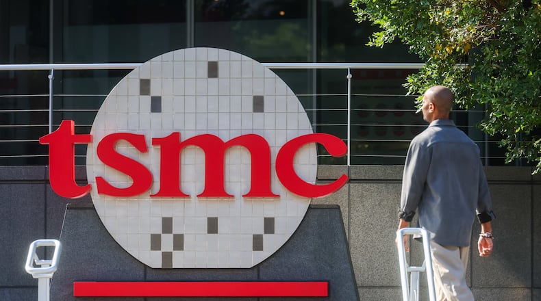 FILE -A worker walks past the logo of TSMC or Taiwan Semiconductor Manufacturing Corp., a Taiwanese multinational semiconductor contract manufacturing and design company, in Hsinchu, Taiwan, on Thursday, Jan. 29, 2026. (AP Photo/Daniel Ceng, File)