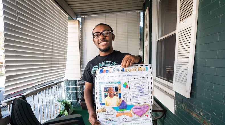 West Chester student Imere Williams, holding a class assignment of his from fourth grade when he wrote that he wanted to be a teacher, at his home in Philadelphia.