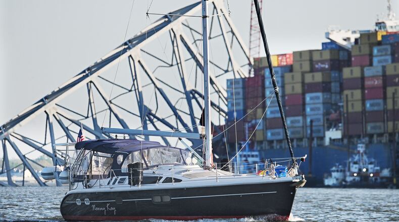 Chuck and JoAnn Anderika onboard their sailboat pass the Key Bridge wreckage through a temporary channel just opened to recreational boaters to enter or leave Baltimore's harbor. They are returning to their home marina Anchorage Marina. (Kenneth K. Lam/Baltimore Sun/TNS)