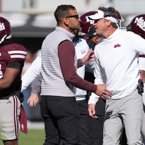 Mississippi head coach Lane Kiffin, right, and Mississippi State director of athletics Zac Selmon, left, confer during a scuffle between the teams in the first half of an NCAA college football game Friday, Nov. 28, 2025, in Starkville, Miss. (AP Photo/Rogelio V. Solis)