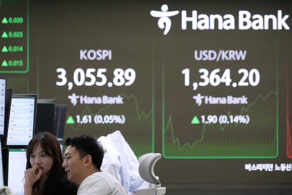 Currency traders watch monitors near a screen showing the Korea Composite Stock Price Index (KOSPI), top left, and the foreign exchange rate between U.S. dollar and South Korean won at the foreign exchange dealing room of the KEB Hana Bank headquarters in Seoul, South Korea, Monday, July 7, 2025. (AP Photo/Ahn Young-joon)