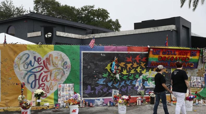 People visit the memorial to the victims of the mass shooting set up around the Pulse nightclub in Orlando, Florida, nightclub.