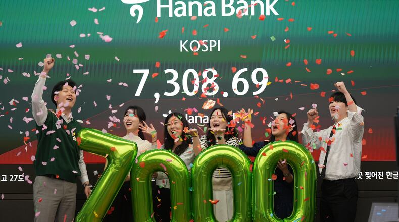 Employees of Hana Bank celebrate in a photo opportunity to mark the Korea Composite Stock Price Index (KOSPI) of over 7,000 points at a dealing room of Hana Bank in Seoul, South Korea, Wednesday, May 6, 2026. (AP Photo/Lee Jin-man)