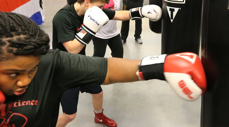 Members of Congress are contemplating whether to allow taxpayers to write-off spending for fitness activities. Some think that could be good for the sweat business. Danielle Huggins (from left), Carter Coffie, and Marty Lewis punch bags while Marty Hill teaches their boxing fitness class at Sweet Science Fitness Boxing Club in Doraville. Curtis Compton/ccompton@ajc.com