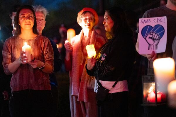 People gather for a candlelight vigil in support of the Centers for Disease Control and Prevention in front of its headquarters in Atlanta, Friday, March 28, 2025. (AP Photo/Ben Gray)