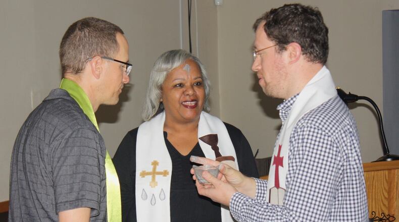 Co-pastors Tim Rodgers, left, and Catherine Gilliard speak with one of the members during an Ash Wednesday service at New Life Covenant Church. Contributed