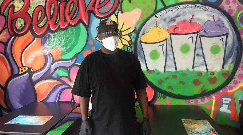 Lemont Bradley stands inside his latest car wash-cafe hybrid, Eco Car Spa and Amazing Salads & Smoothies, on Northside Drive. Bradley also owns Auto Spa Bistro, which offers a car wash and detailing, as well as food and cocktails, nearby on 14th Street. LIGAYA FIGUERAS / LIGAYA.FIGUERAS@AJC.COM