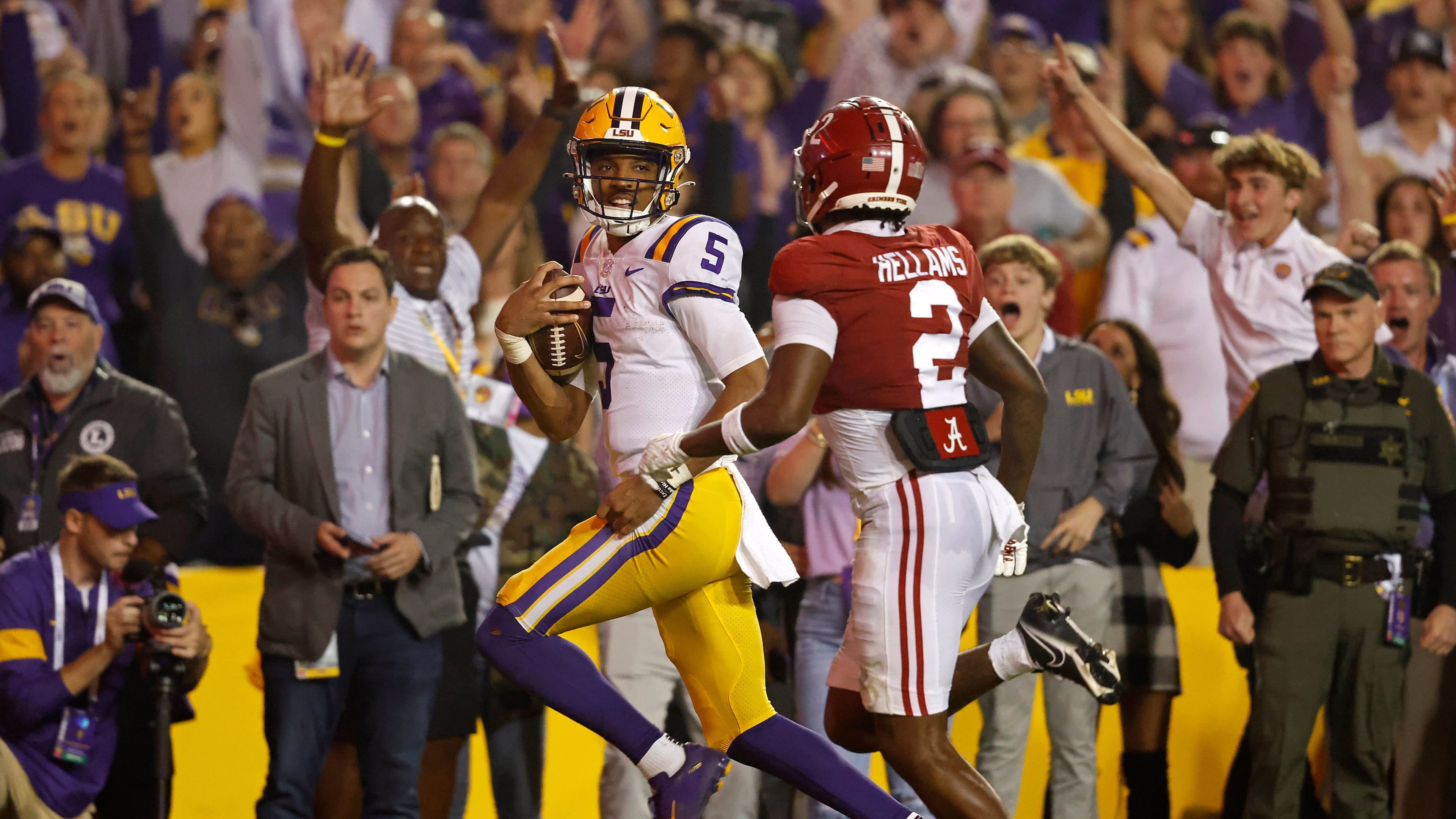 FILE - LSU quarterback Jayden Daniels (5) runs the ball past Alabama defensive back DeMarcco Hellams (2) to score a two-point conversion during overtime of an NCAA college football game in Baton Rouge, La., Nov. 5, 2022. (AP Photo/Tyler Kaufman, File)