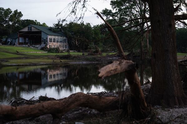 FILE - Camp Mystic is reflected in water after a flash flood swept through the area July 7, 2025, in Hunt, Texas. (AP Photo/Eli Hartman, File)