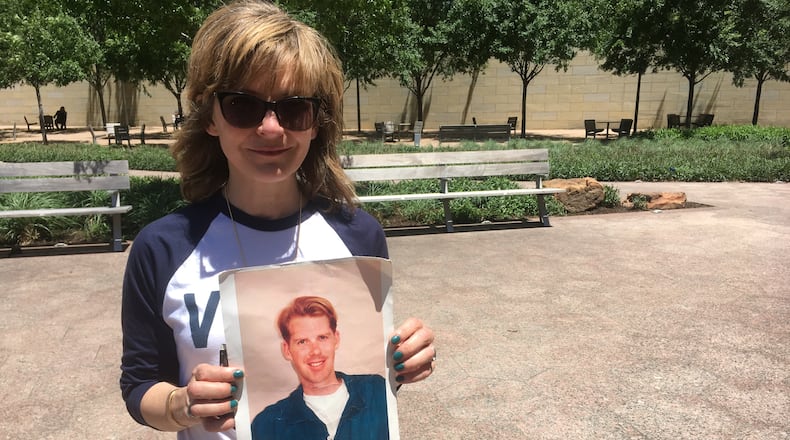 Kim Russell with a photo of her friend Philip Rau, who was shot to death in Inman Park in 1999, at a Dallas rally protesting the NRA's political clout. Photo: Jennifer Brett, jbrett@ajc.com