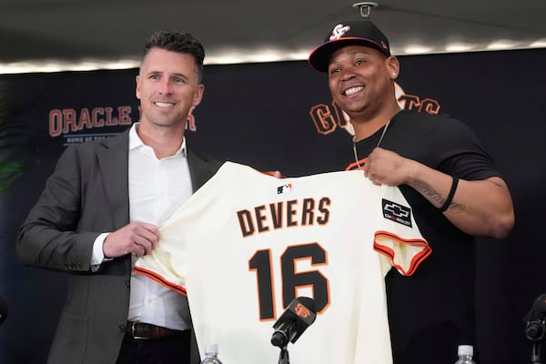 San Francisco Giants' Rafael Devers, right, poses for photos with President of Baseball Operations Buster Posey at a news conference before a baseball game between the Giants and the Cleveland Guardians in San Francisco, Tuesday, June 17, 2025. (AP Photo/Jeff Chiu)