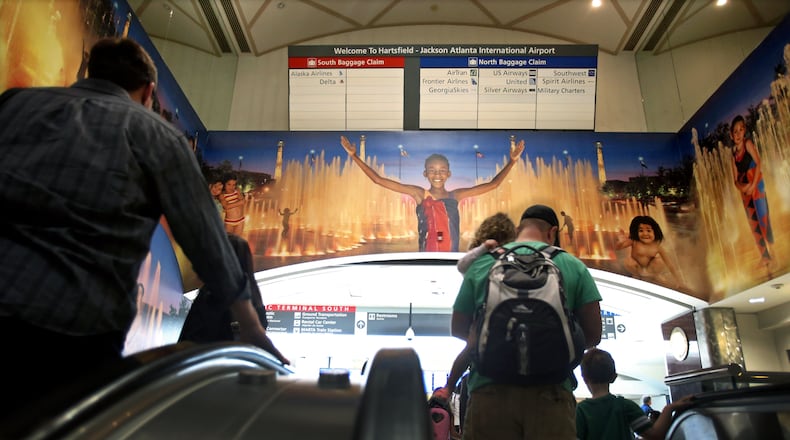 April 23, 2013 - Atlanta, Ga: After traveling on the automated people movers, paassengers travel up the long escalator where the well-known mural welcomes visitors to Atlanta at Hartsfield-Jackson Atlanta International Airport Tuesday morning in Atlanta, Ga., April 23, 2013. Nearly a year after the Atlanta airport opened its new international terminal, it is already planning for the next expansion. Hartsfield-Jackson International Airport's master plan study shows the airport will soon need more parking, and will also need more people-mover train capacity inside the terminal, more security screening line space, more gates and more airfield capacity - such as another runway -- in the next 20 years JASON GETZ / JGETZ@AJC.COM
