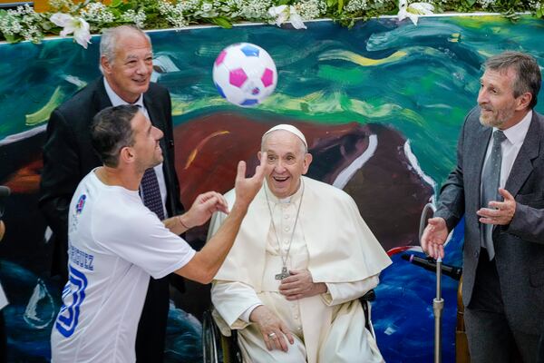 Pope Francis and Scholas Occurrentes' President Jose Maria Del Corral, left, look at Newell's Old Boys captain, Argentine midfielder Maxi Rodriguez juggling a soccer ball at the launch of the 'Scholas Occurrentes' (Latin for, schools of meeting) international educational movement at the pontifical Urbaniana University in Rome, Thursday, May 19, 2022. (AP Photo/Andrew Medichini)