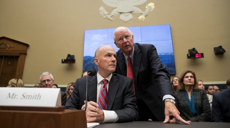 Former chairman and CEO of Equifax Richard F. Smith, talks with former Sen. Saxby Chambliss, R-Ga., as he takes his seat to testify before the Digital Commerce and Consumer Protection Subcommittee of the House Commerce Committee on Capitol Hill in Washington, Tuesday, Oct. 3, 2017. AP Photo/Carolyn Kaster)