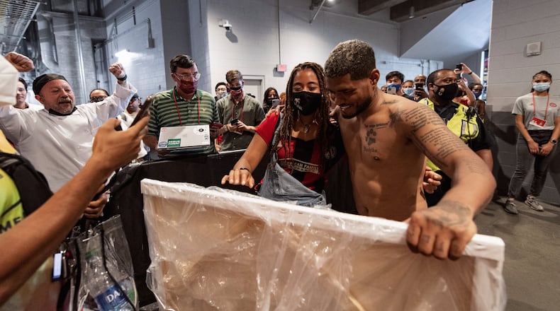 Atlanta United's Josef Martinez looks at a painting of him done by a lock artist, Lindsay.
