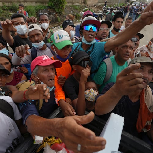 People reach out to receive supplies from volunteers, days after an earthquake struck La Guaira, Venezuela, Tuesday, June 30, 2026. (AP Photo/Matias Delacroix)