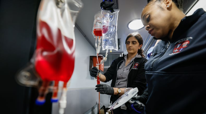 Paramedics at Grady Nicole Wilkerson (right) and Ned Vidal work through a training session on implementing a blood transfusion inside of a Quick Response Vehicle at the Grady EMS Headquarters in Atlanta. (Miguel Martinez /miguel.martinezjimenez@ajc.com)