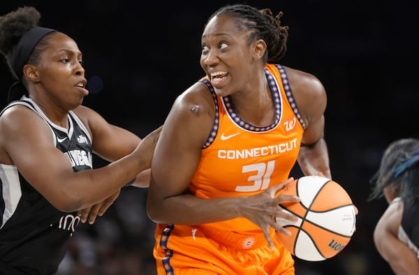 Las Vegas Aces guard Chelsea Gray (12) defends against Connecticut Sun center Tina Charles (31) during the first half of a WNBA basketball game, Wednesday, June 25, 2025, in Las Vegas. (Steve Marcus/Las Vegas Sun via AP)