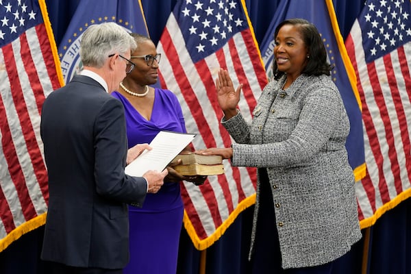 Lisa Cook (right) is pictured taking the oath of office to become a member of the Federal Reserve Board three years ago in Washington.