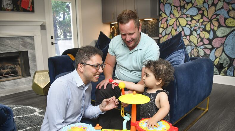 Derek Mize, in the light green shirt, and Jonathan Gregg got married and wanted to start a family. They did so through surrogacy, but now their daughter, Simone, is being denied citizenship by the U.S. Department of State. The couple is suing the department.